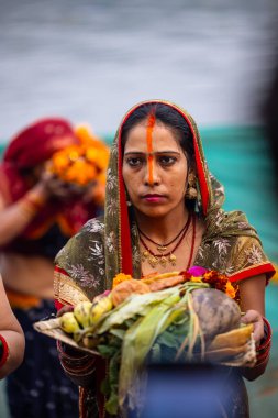 Gaziabad, Uttar Pradesh, Hindistan - 30 Ekim 2022: Chhas Puja, Hintli kadın dindar gün batımında Lord Sun 'a ibadet etmek için nehirde dururken Chhas puja ayini yapıyor..