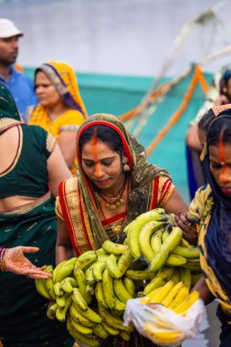 Gaziabad, Uttar Pradesh, Hindistan - 30 Ekim 2022: Chhas Puja, Hintli kadın dindar gün batımında Lord Sun 'a ibadet etmek için nehirde dururken Chhas puja ayini yapıyor..