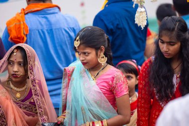 Ghaziabad, Uttar Pradesh, India - October 30 2022: Chhath Puja, Indian hindu female devotee performing rituals of chhath puja while standing in river to worship lord sun during sunset. clipart