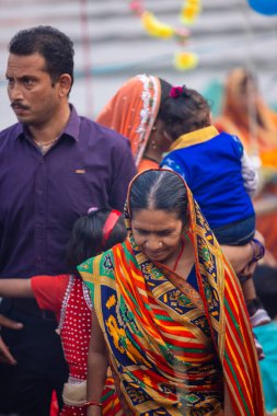 Gaziabad, Uttar Pradesh, Hindistan - 30 Ekim 2022: Chhas Puja, Hintli kadın dindar gün batımında Lord Sun 'a ibadet etmek için nehirde dururken Chhas puja ayini yapıyor..