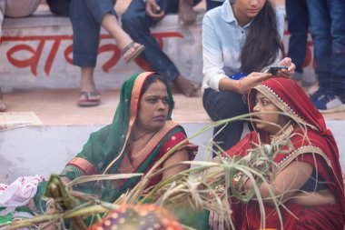 Gaziabad, Uttar Pradesh, Hindistan - 30 Ekim 2022: Chhas Puja, Hintli kadın dindar gün batımında Lord Sun 'a ibadet etmek için nehirde dururken Chhas puja ayini yapıyor..