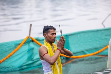 Gaziabad, Uttar Pradesh, Hindistan - 30 Ekim 2022: Chhas Puja, Hintli kadın dindar gün batımında Lord Sun 'a ibadet etmek için nehirde dururken Chhas puja ayini yapıyor..