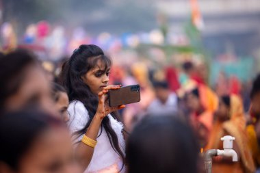 Gaziabad, Uttar Pradesh, Hindistan - 30 Ekim 2022: Chhas Puja, Hintli kadın dindar gün batımında Lord Sun 'a ibadet etmek için nehirde dururken Chhas puja ayini yapıyor..
