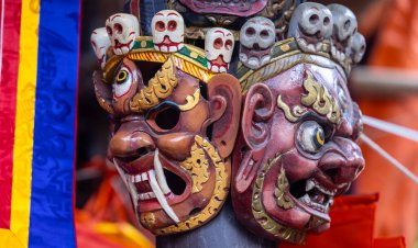 Handmade colorful tribal look face mask souvenir hanging on plain background. Selective focus on object.