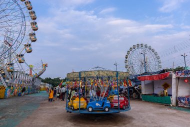 Gaziabad, Uttar Pradesh, Hindistan - 05 Ekim 2022: Geceleyin gerçekleşen dussehra fuarı sırasında turistler panayırda ortak tekerlek sürüşünün keyfini çıkarıyorlar.