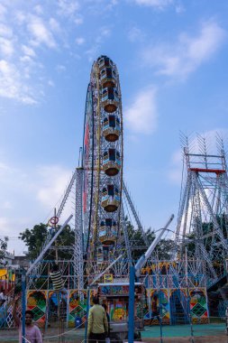 Gaziabad, Uttar Pradesh, Hindistan - 05 Ekim 2022: Geceleyin gerçekleşen dussehra fuarı sırasında turistler panayırda ortak tekerlek sürüşünün keyfini çıkarıyorlar.