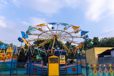 Gaziabad, Uttar Pradesh, Hindistan - 05 Ekim 2022: Geceleyin gerçekleşen dussehra fuarı sırasında turistler panayırda ortak tekerlek sürüşünün keyfini çıkarıyorlar.