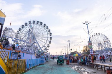 Gaziabad, Uttar Pradesh, Hindistan - 05 Ekim 2022: Geceleyin gerçekleşen dussehra fuarı sırasında turistler panayırda ortak tekerlek sürüşünün keyfini çıkarıyorlar.