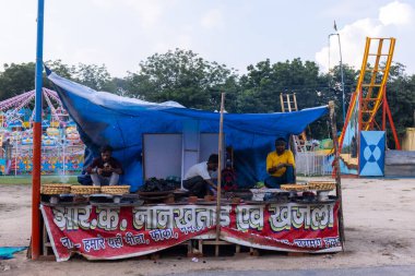 Gaziabad, Uttar Pradesh, Hindistan - 05 Ekim 2022: Geceleyin gerçekleşen dussehra fuarı sırasında turistler panayırda ortak tekerlek sürüşünün keyfini çıkarıyorlar.