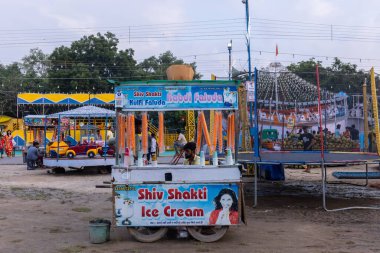 Gaziabad, Uttar Pradesh, Hindistan - 05 Ekim 2022: Geceleyin gerçekleşen dussehra fuarı sırasında turistler panayırda ortak tekerlek sürüşünün keyfini çıkarıyorlar.