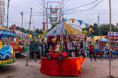 Gaziabad, Uttar Pradesh, Hindistan - 05 Ekim 2022: Geceleyin gerçekleşen dussehra fuarı sırasında turistler panayırda ortak tekerlek sürüşünün keyfini çıkarıyorlar.