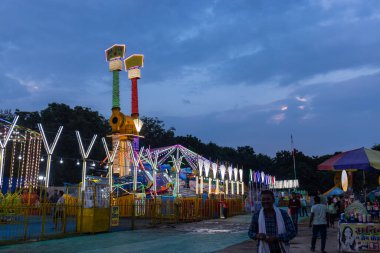 Gaziabad, Uttar Pradesh, Hindistan - 05 Ekim 2022: Geceleyin gerçekleşen dussehra fuarı sırasında turistler panayırda ortak tekerlek sürüşünün keyfini çıkarıyorlar.