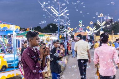 Gaziabad, Uttar Pradesh, Hindistan - 05 Ekim 2022: Geceleyin gerçekleşen dussehra fuarı sırasında turistler panayırda ortak tekerlek sürüşünün keyfini çıkarıyorlar.