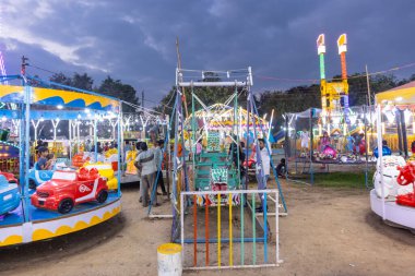 Gaziabad, Uttar Pradesh, Hindistan - 05 Ekim 2022: Geceleyin gerçekleşen dussehra fuarı sırasında turistler panayırda ortak tekerlek sürüşünün keyfini çıkarıyorlar.