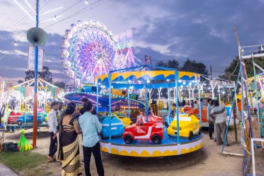 Gaziabad, Uttar Pradesh, Hindistan - 05 Ekim 2022: Geceleyin gerçekleşen dussehra fuarı sırasında turistler panayırda ortak tekerlek sürüşünün keyfini çıkarıyorlar.