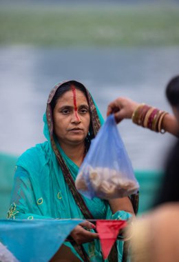 Gaziabad, Uttar Pradesh, Hindistan - 30 Ekim 2022: Chhas Puja, Hintli kadın dindar gün batımında Lord Sun 'a ibadet etmek için nehirde dururken Chhas puja ayini yapıyor..