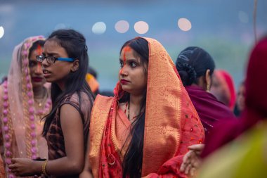 Gaziabad, Uttar Pradesh, Hindistan - 30 Ekim 2022: Chhas Puja, Hintli kadın dindar gün batımında Lord Sun 'a ibadet etmek için nehirde dururken Chhas puja ayini yapıyor..