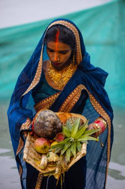 Gaziabad, Uttar Pradesh, Hindistan - 30 Ekim 2022: Chhas Puja, Hintli kadın dindar gün batımında Lord Sun 'a ibadet etmek için nehirde dururken Chhas puja ayini yapıyor..