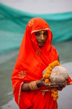 Gaziabad, Uttar Pradesh, Hindistan - 30 Ekim 2022: Chhas Puja, Hintli kadın dindar gün batımında Lord Sun 'a ibadet etmek için nehirde dururken Chhas puja ayini yapıyor..