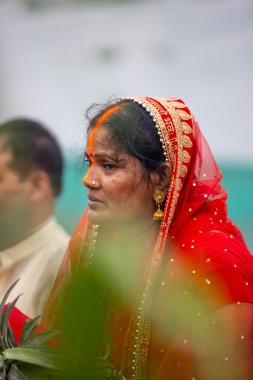 Gaziabad, Uttar Pradesh, Hindistan - 30 Ekim 2022: Chhas Puja, Hintli kadın dindar gün batımında Lord Sun 'a ibadet etmek için nehirde dururken Chhas puja ayini yapıyor..