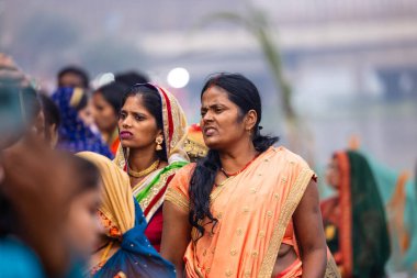 Gaziabad, Uttar Pradesh, Hindistan - 30 Ekim 2022: Chhas Puja, Hintli kadın dindar gün batımında Lord Sun 'a ibadet etmek için nehirde dururken Chhas puja ayini yapıyor..