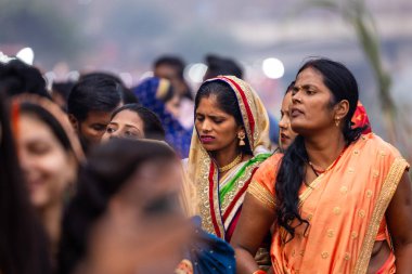 Gaziabad, Uttar Pradesh, Hindistan - 30 Ekim 2022: Chhas Puja, Hintli kadın dindar gün batımında Lord Sun 'a ibadet etmek için nehirde dururken Chhas puja ayini yapıyor..