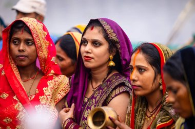 Gaziabad, Uttar Pradesh, Hindistan - 30 Ekim 2022: Chhas Puja, Hintli kadın dindar gün batımında Lord Sun 'a ibadet etmek için nehirde dururken Chhas puja ayini yapıyor..