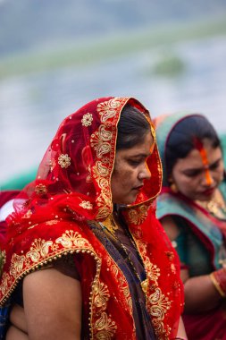 Gaziabad, Uttar Pradesh, Hindistan - 30 Ekim 2022: Chhas Puja, Hintli kadın dindar gün batımında Lord Sun 'a ibadet etmek için nehirde dururken Chhas puja ayini yapıyor..