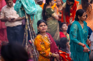Gaziabad, Uttar Pradesh, Hindistan - 30 Ekim 2022: Chhas Puja, Hintli kadın dindar gün batımında Lord Sun 'a ibadet etmek için nehirde dururken Chhas puja ayini yapıyor..