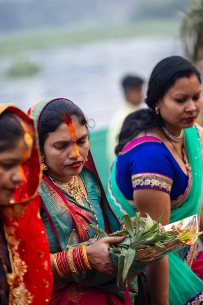 Gaziabad, Uttar Pradesh, Hindistan - 30 Ekim 2022: Chhas Puja, Hintli kadın dindar gün batımında Lord Sun 'a ibadet etmek için nehirde dururken Chhas puja ayini yapıyor..