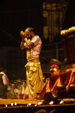 Varanasi, Uttar Pradesh, Hindistan - 3 Mart 2023: Ganga aarti, Dashashwamedh ghat geleneksel elbise ve Hindu ayinleri ile kutsal nehir ganges akşam aarti performans genç rahip portresi