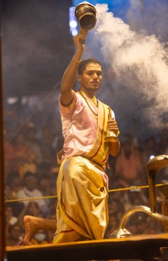 Varanasi, Uttar Pradesh, Hindistan - 3 Mart 2023: Ganga aarti, Dashashwamedh ghat geleneksel elbise ve Hindu ayinleri ile kutsal nehir ganges akşam aarti performans genç rahip portresi