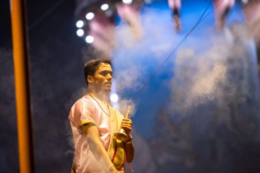 Varanasi, Uttar Pradesh, Hindistan - 3 Mart 2023: Ganga aarti, Dashashwamedh ghat geleneksel elbise ve Hindu ayinleri ile kutsal nehir ganges akşam aarti performans genç rahip portresi