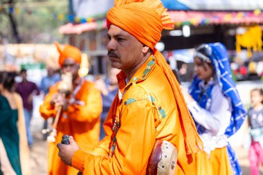 Faridabad, Haryana, Hindistan - 4 Şubat 2023: Turistleri cezbetmek için etnik elbise giymiş surajkund zanaat fuarı sırasında erkek yılan oynatıcının portresi.