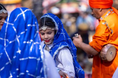 Faridabad, Haryana, Hindistan - 4 Şubat 2023: Surajkund fuarı sırasında Haryana 'nın etnik elbise ve mücevherleriyle dans eden güzel kızlar.