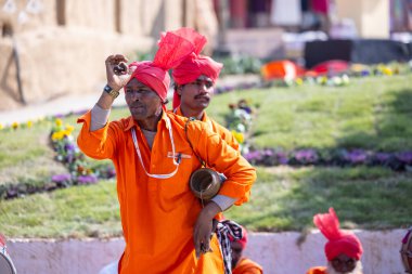 Faridabad, Haryana, Hindistan - 4 Şubat 2023: Turistleri cezbetmek için etnik elbise giymiş surajkund zanaat fuarı sırasında erkek yılan oynatıcının portresi.