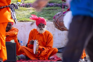 Faridabad, Haryana, Hindistan - 4 Şubat 2023: Turistleri cezbetmek için etnik elbise giymiş surajkund zanaat fuarı sırasında erkek yılan oynatıcının portresi.