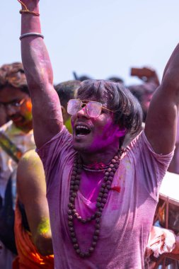 Varanasi, Uttar Pradesh, Hindistan - 04 Mart 2023: Masan Holi, Holi bayramını kutlamak için Mankarnika ghat 'ında boyanmış yüzlerle damru oynayan insanlar