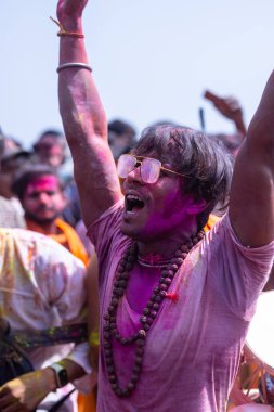 Varanasi, Uttar Pradesh, Hindistan - 04 Mart 2023: Masan Holi, Holi bayramını kutlamak için Mankarnika ghat 'ında boyanmış yüzlerle damru oynayan insanlar