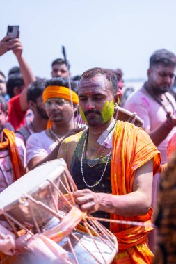 Varanasi, Uttar Pradesh, Hindistan - 04 Mart 2023: Masan Holi, Holi bayramını kutlamak için Mankarnika ghat 'ında boyanmış yüzlerle damru oynayan insanlar