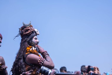 Varanasi, Uttar Pradesh, Hindistan - Mart 04: 2023: Masan Holi, Varanasi 'deki manikarnika ghat' ta düzenlenen masaan holi kutlamaları sırasında yüzünü boyayan erkek ressamın portresi.