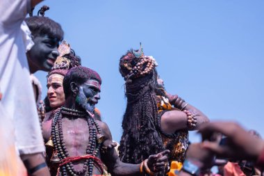 Varanasi, Uttar Pradesh, Hindistan - Mart 04: 2023: Masan Holi, Varanasi 'deki manikarnika ghat' ta düzenlenen masaan holi kutlamaları sırasında yüzünü boyayan erkek ressamın portresi.