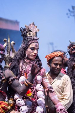 Varanasi, Uttar Pradesh, Hindistan - Mart 04: 2023: Masan Holi, Varanasi 'deki manikarnika ghat' ta düzenlenen masaan holi kutlamaları sırasında yüzünü boyayan erkek ressamın portresi.