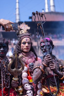 Varanasi, Uttar Pradesh, Hindistan - Mart 04: 2023: Masan Holi, Varanasi 'deki manikarnika ghat' ta düzenlenen masaan holi kutlamaları sırasında yüzünü boyayan erkek ressamın portresi.