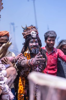 Varanasi, Uttar Pradesh, Hindistan - Mart 04, 2023: Masan Holi, Varanasi 'deki manikarnika ghat' ında düzenlenen masaan holi kutlaması sırasında yüzünü boyayan bir erkek sanatçının portresi.