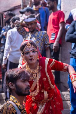 Varanasi, Uttar Pradesh, Hindistan - Mart 04: 2023: Masan Holi, Varanasi 'deki manikarnika ghat' ta düzenlenen masaüstü bayramında tanrıça Parvati gibi davranan yüzü boyalı bir kadın sanatçı portresi