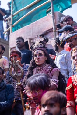 Varanasi, Uttar Pradesh, Hindistan - Mart 04, 2023: Masan Holi, Varanasi 'deki manikarnika ghat' ında düzenlenen masaan holi kutlaması sırasında yüzünü boyayan bir erkek sanatçının portresi.