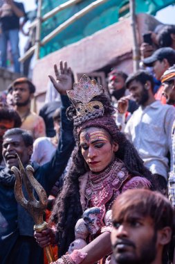 Varanasi, Uttar Pradesh, Hindistan - Mart 04, 2023: Masan Holi, Varanasi 'deki manikarnika ghat' ında düzenlenen masaan holi kutlaması sırasında yüzünü boyayan bir erkek sanatçının portresi.