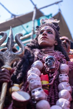 Varanasi, Uttar Pradesh, Hindistan - Mart 04: 2023: Masan Holi, Varanasi 'deki manikarnika ghat' taki masaan holi kutlamaları sırasında yüzünü boyayan bir erkek sanatçının portresi.