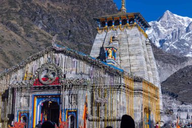 Kedarnath, Uttarakhand, India - October 14 2022: Baba kedarnath temple with snow covered himalayan mountains in background. Kedarnath temple is one of the lord shiva jyotirlinga and sacred place clipart